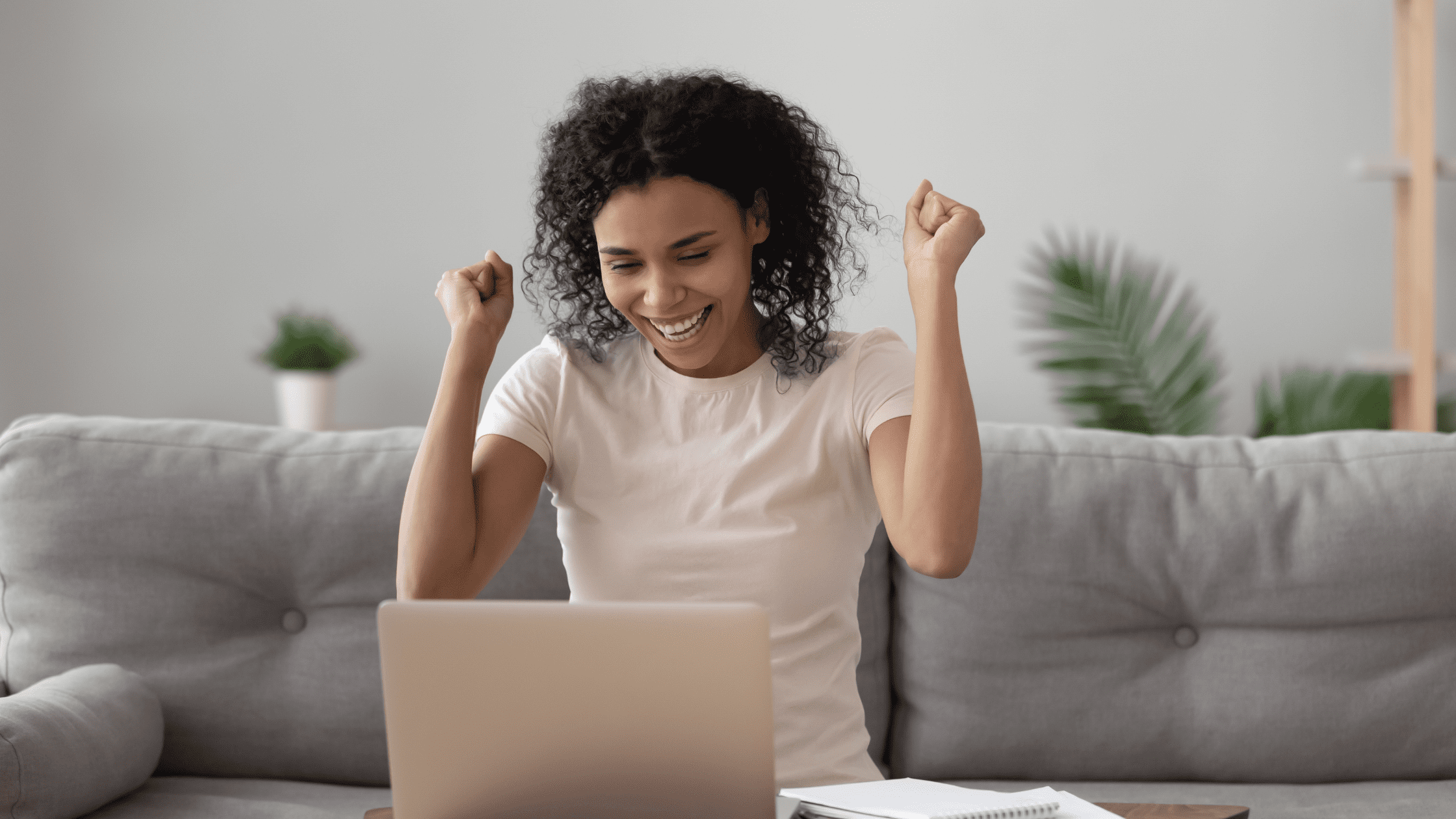 An excited pre-med student looking at her 99th percentile MCAT score on her laptop.