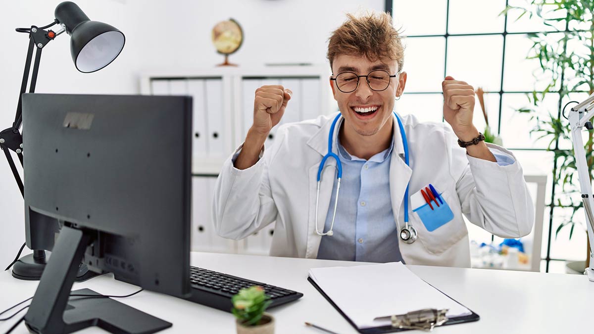 An excited medical school student sitting in front of a computer after having found out his Step 2 CK score.