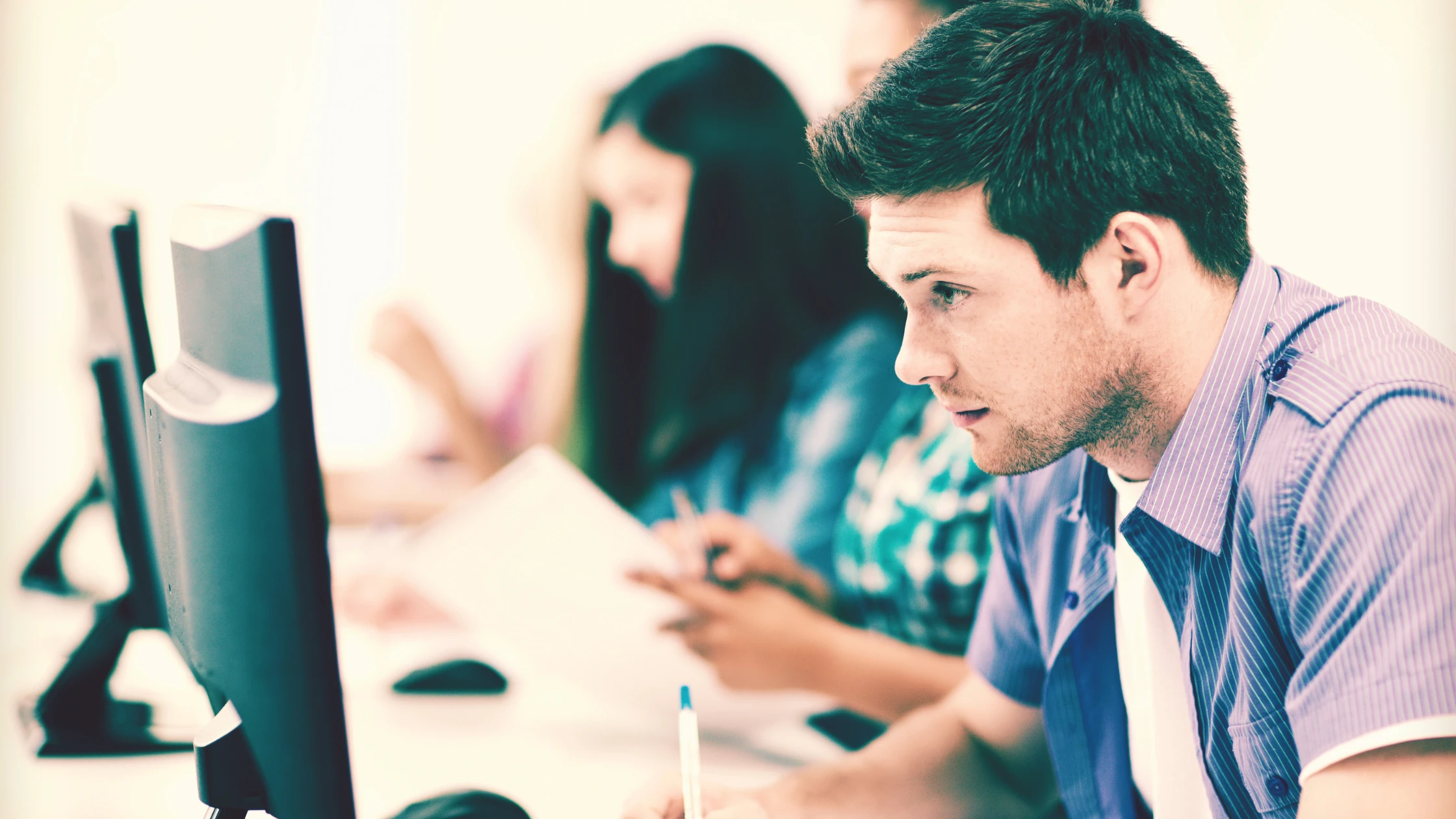 Student focused on a computer while taking the MCAT in a testing center.