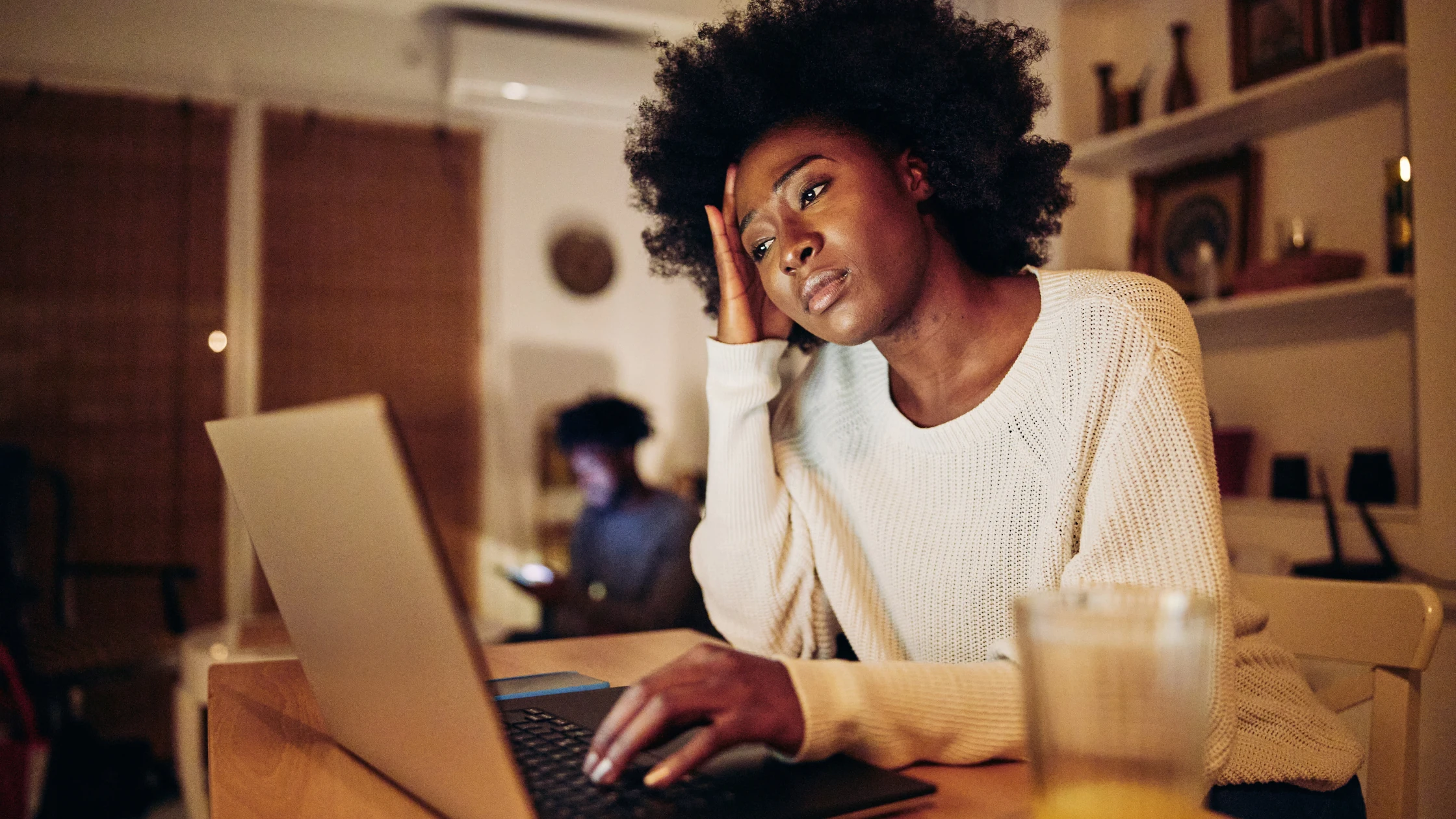 Student looking stressed while studying on a laptop, reflecting challenges faced by Caribbean medical school students.