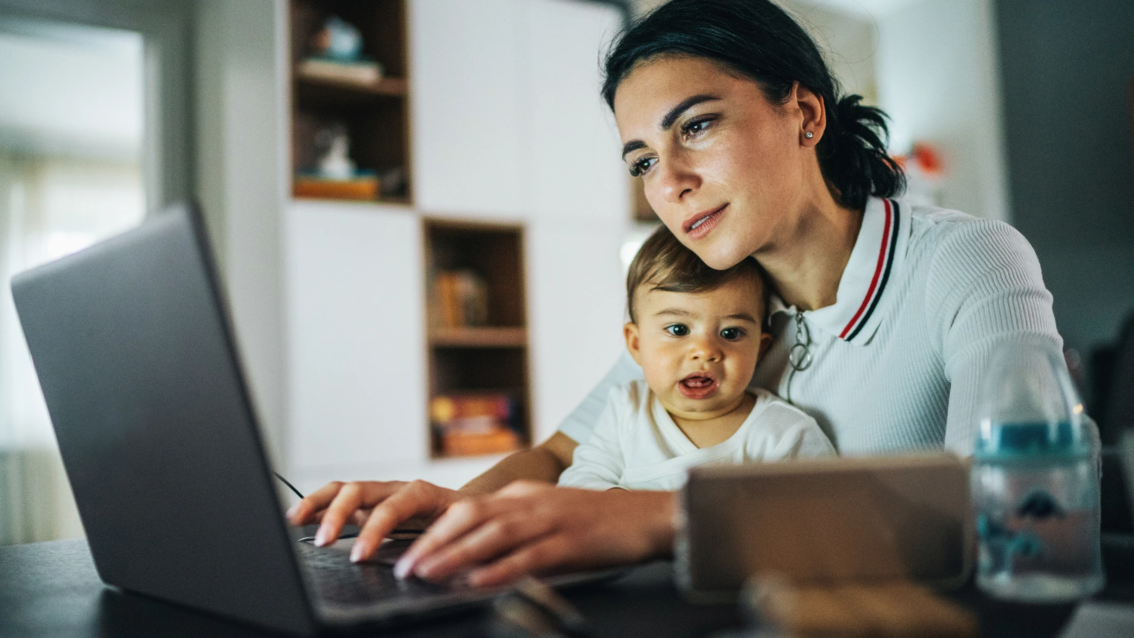 A non-traditional medical student studying for Step 2 at home while balancing parenting, with a baby on her lap.